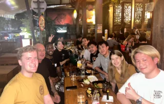 Some of the Bangkok team smiling at the camera whilst enjoying their food and drink