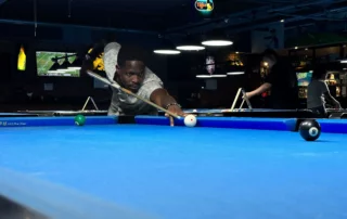 Chris focuses on potting the black ball in a game of pool whilst on his exchange trip to Bangkok